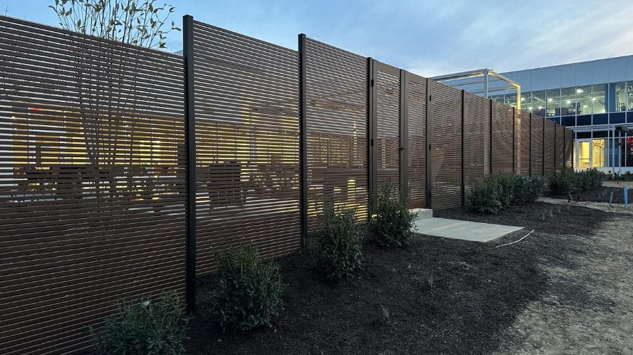 Full View of Wood Finish High Fence and Pedestrian Gate with Clean Landscaping