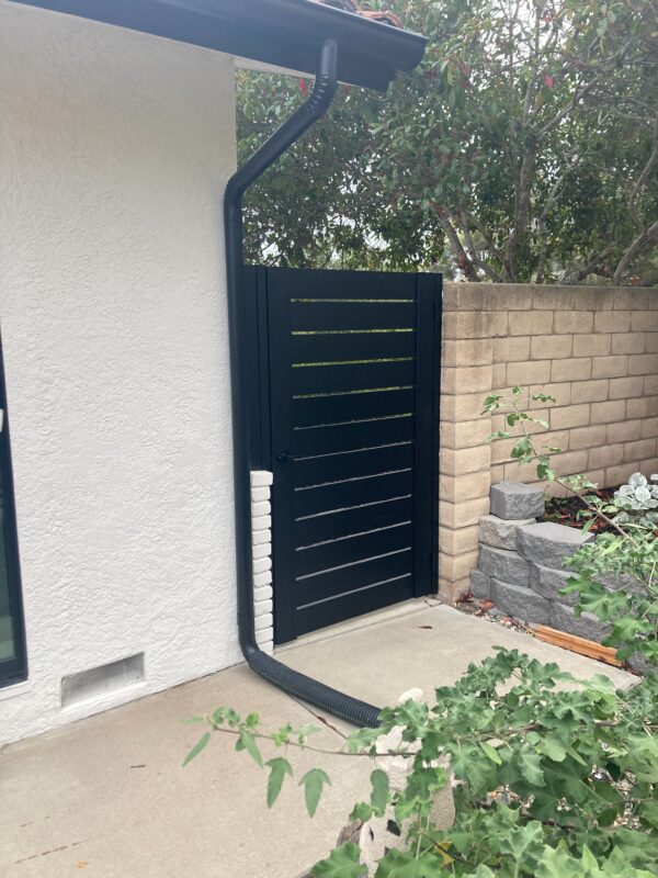 Front View of a Black Pedestrian Gate Installed On Side of a House