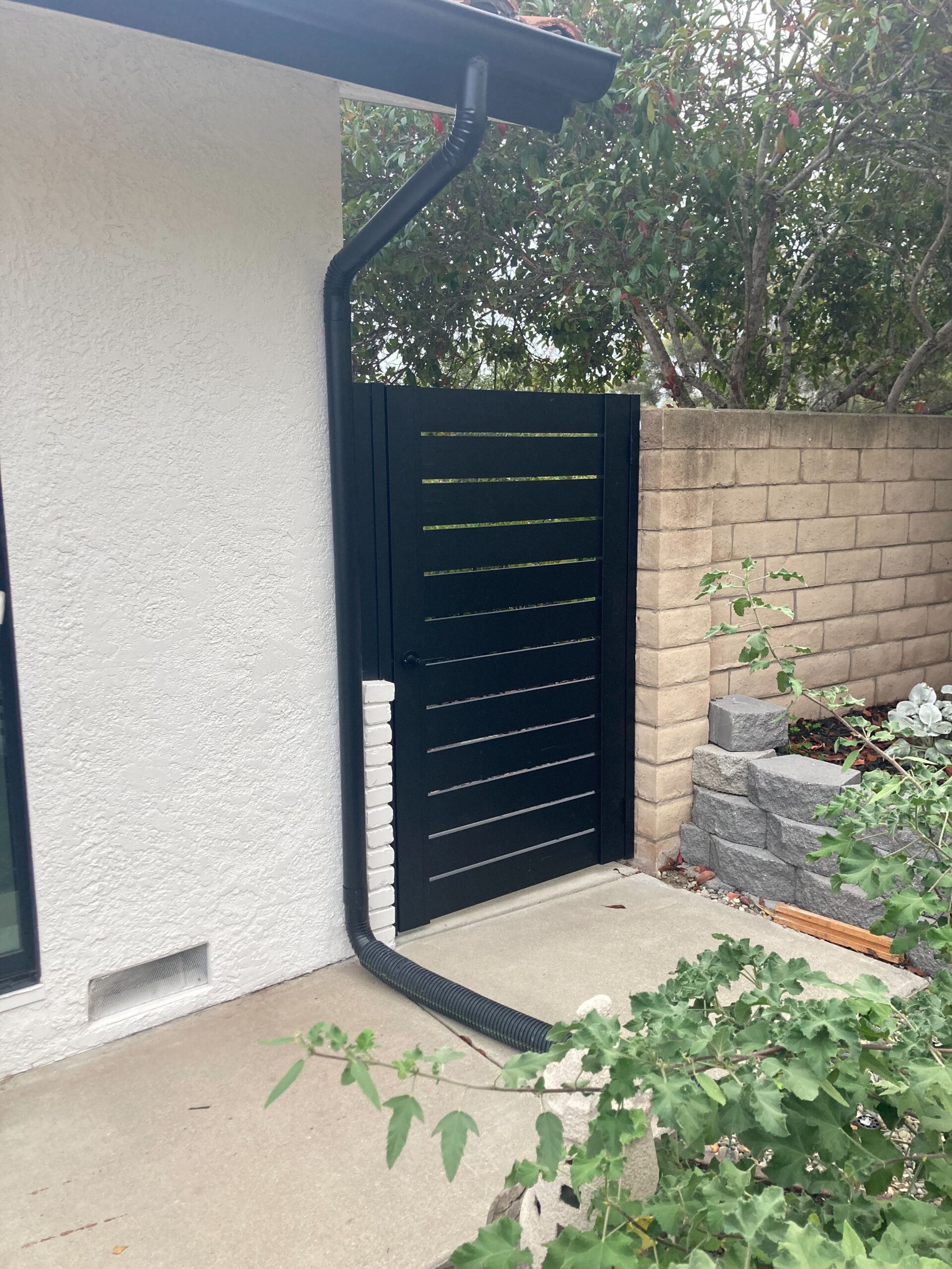 Front View of a Black Pedestrian Gate Installed On Side of a House