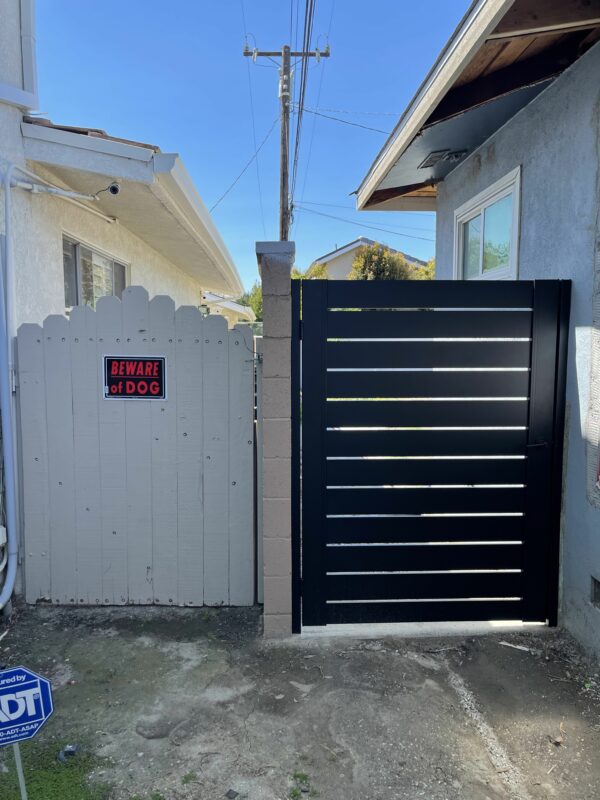 Aluminum Pedestrian Gate installed on side of home. Side by side comparison of aluminum gate and wooden gate