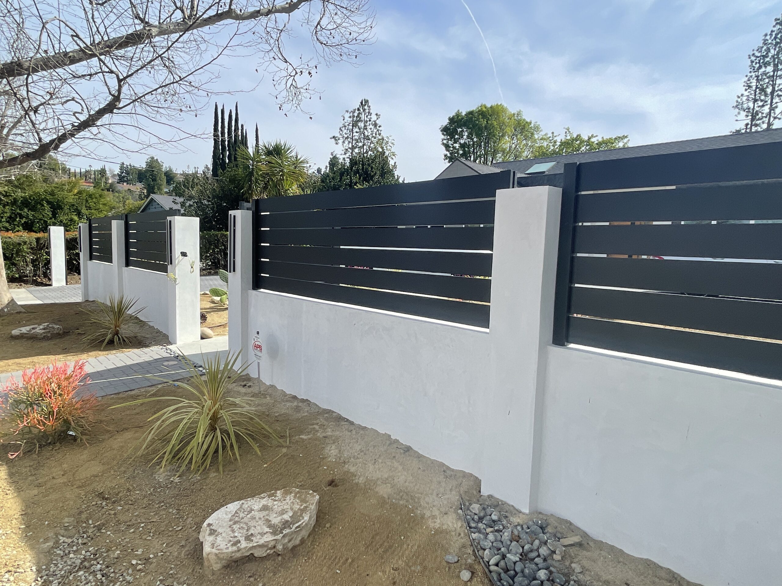 Black Wall Topper in Los Angeles Style with a Pedestrian Gate Being Installed