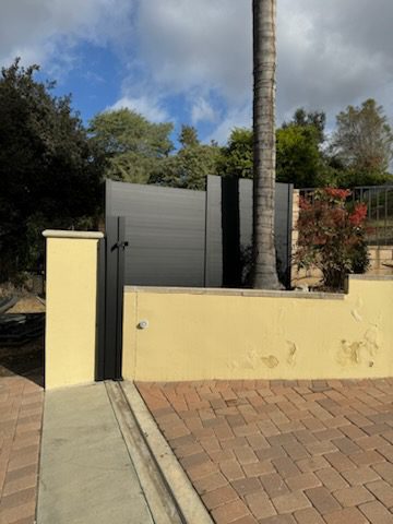 A modern sliding driveway gate blending security and style in a residential setting.