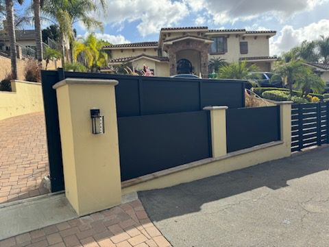 Modern black sliding driveway gate enhances security and aesthetics for a property.