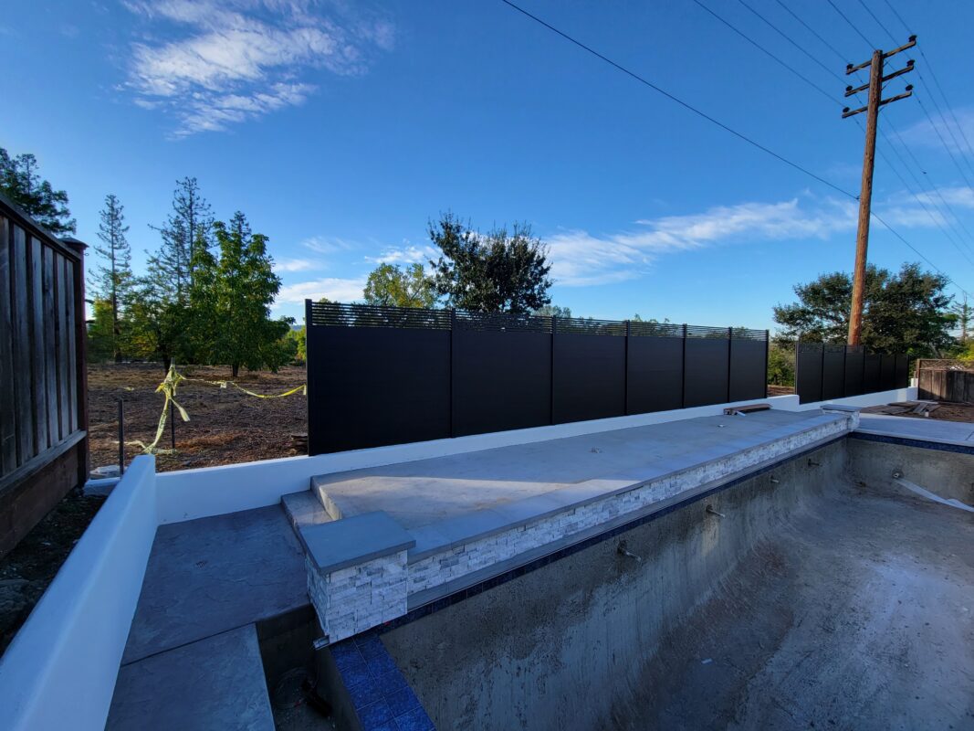 Installation of modern black aluminum fence panels around a pool area in Walnut Creek.