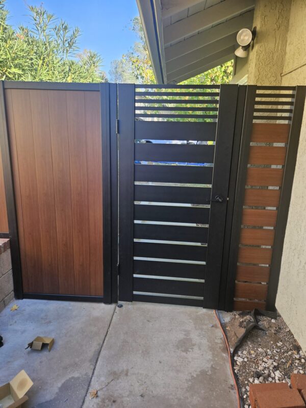 Modern black and wood pedestrian gate enhancing the entryway with style and privacy.