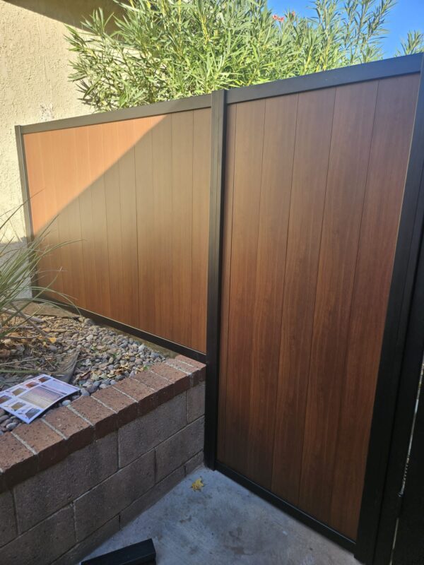 Close-up of a sleek black and wood pedestrian gate in a residential setting.