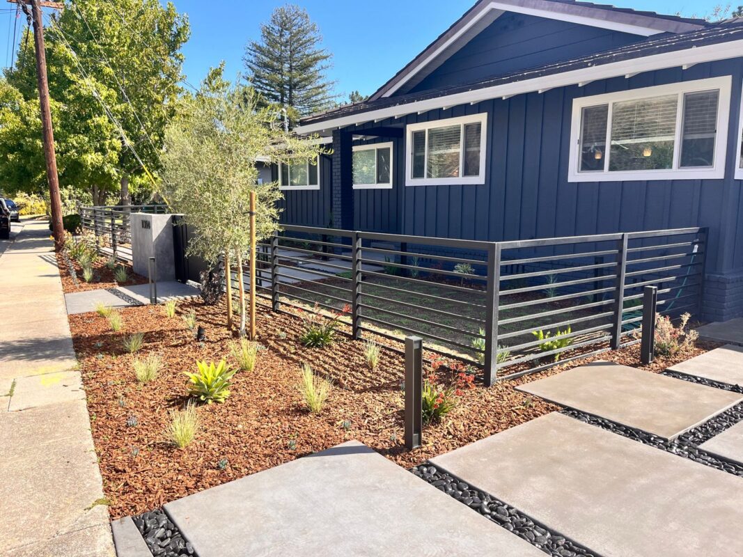 A modern black fence with a top rail around a landscaped home in San Carlos, CA.