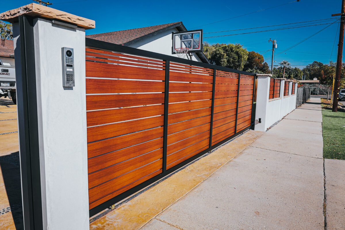 Modern aluminum fence installation resembling wood for enhanced property aesthetics.