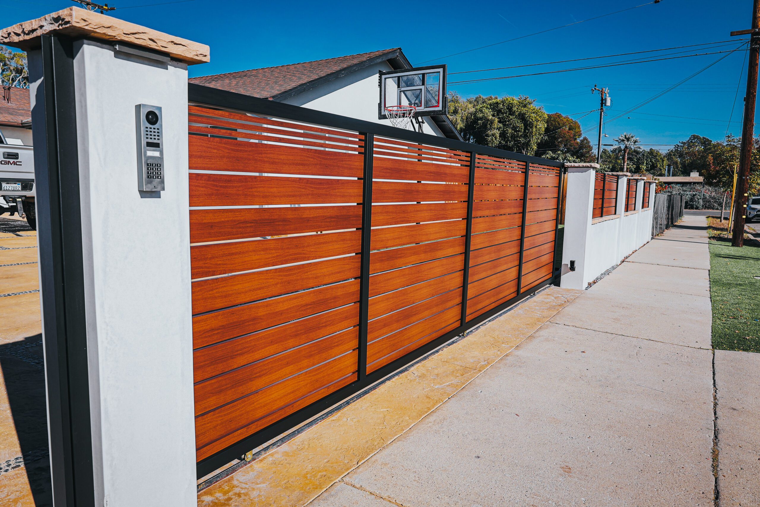 Modern aluminum fence installation resembling wood for enhanced property aesthetics.