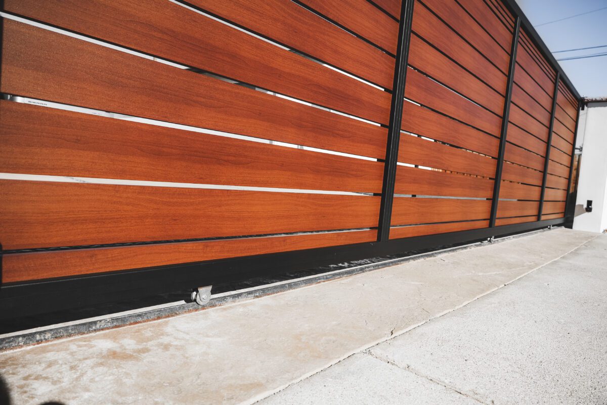A close-up of a modern aluminum fence with a wood-like finish and sleek design.
