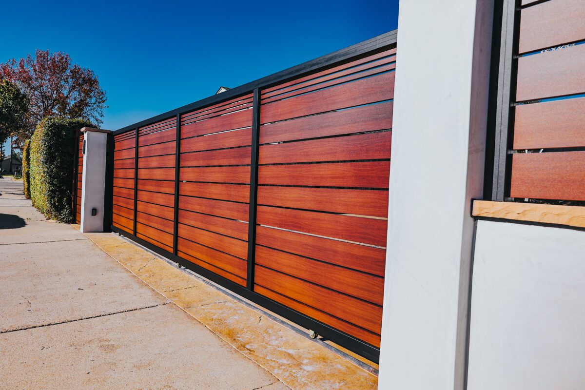 Modern aluminum fence with wood-like finish, enhancing property aesthetics.