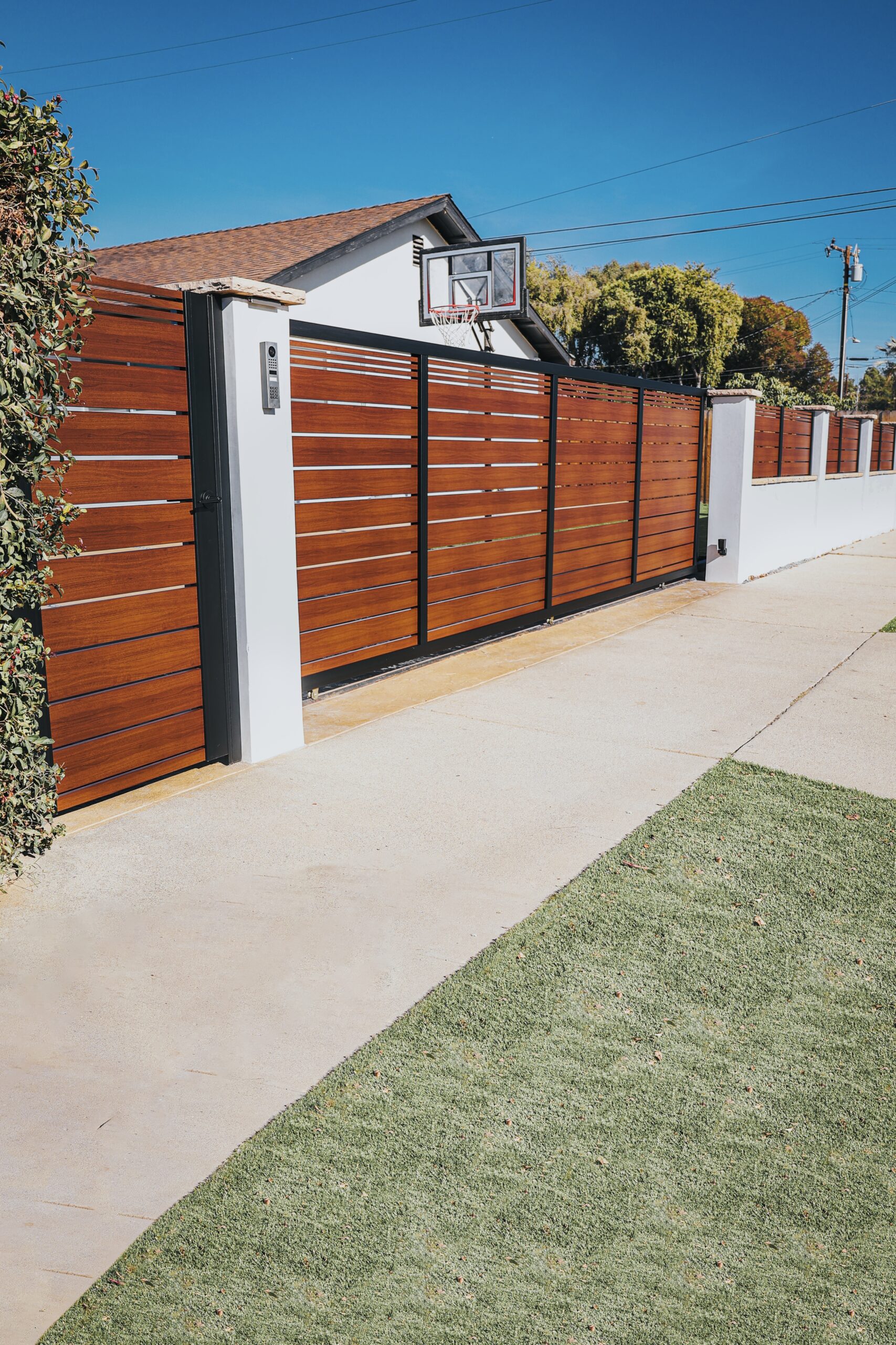 Modern aluminum fence with a wood-like finish installed in a residential area.
