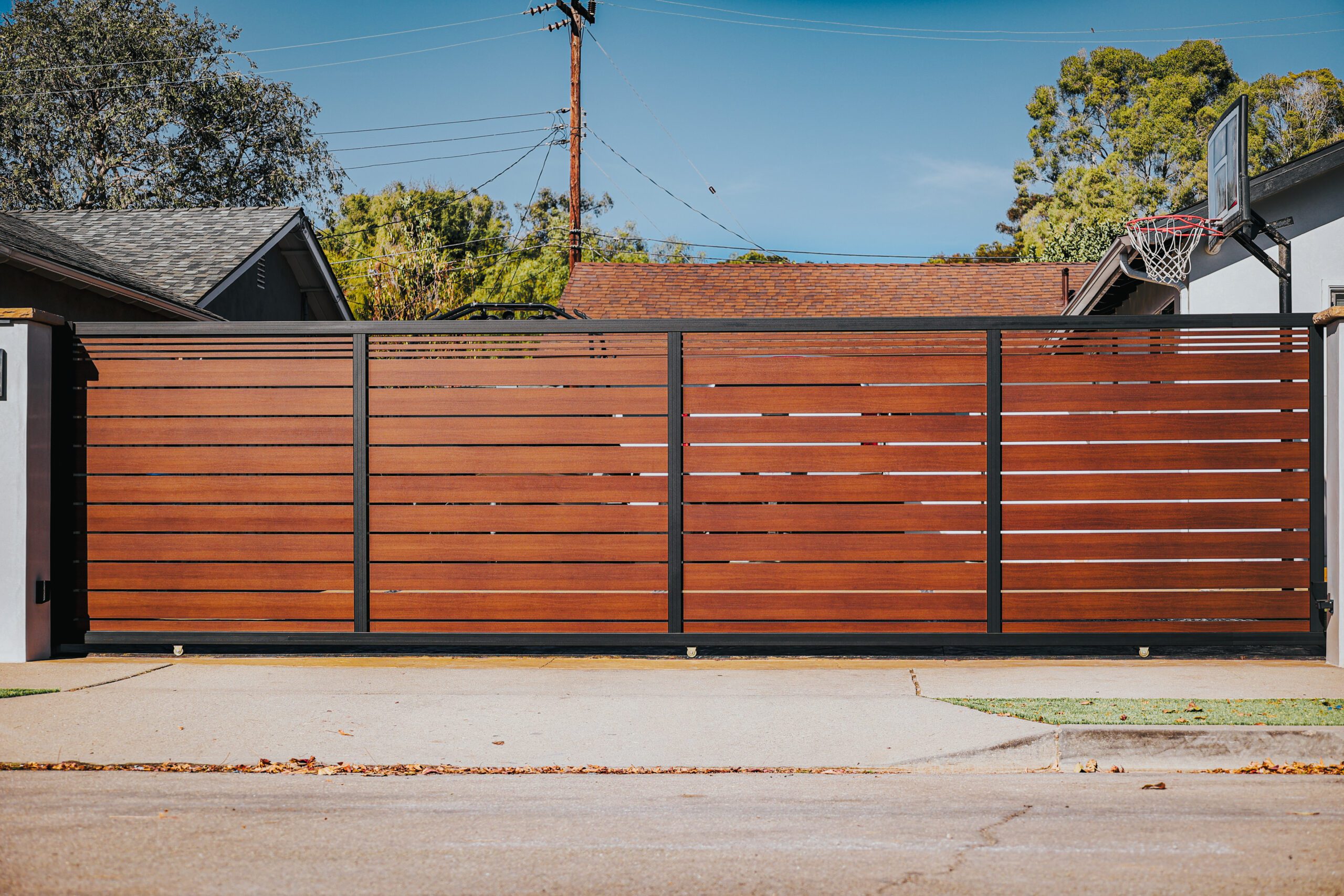 Modern aluminum fence with wood-like appearance, installed in a residential area.