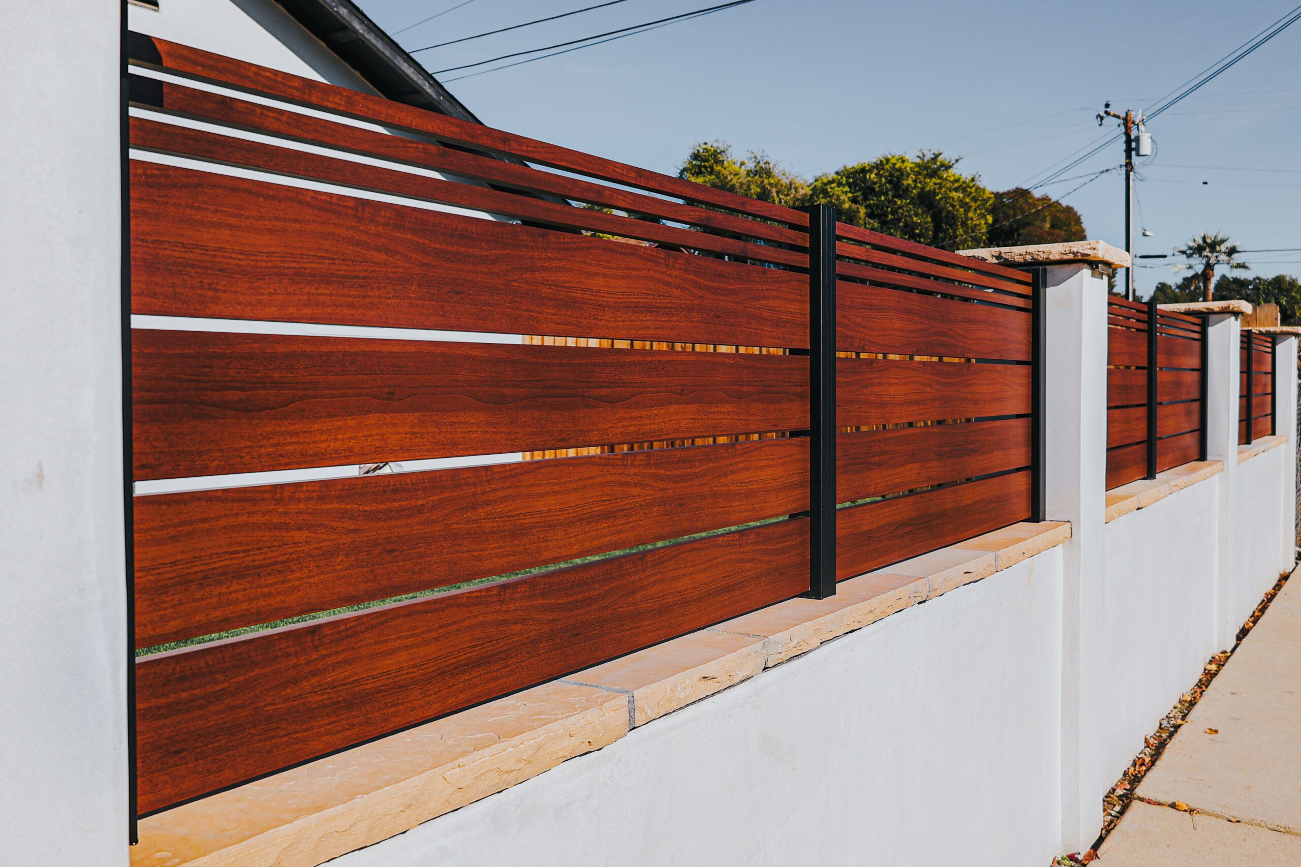 Modern aluminum fence with a 'Look Like Wood' design, enhancing property aesthetics.