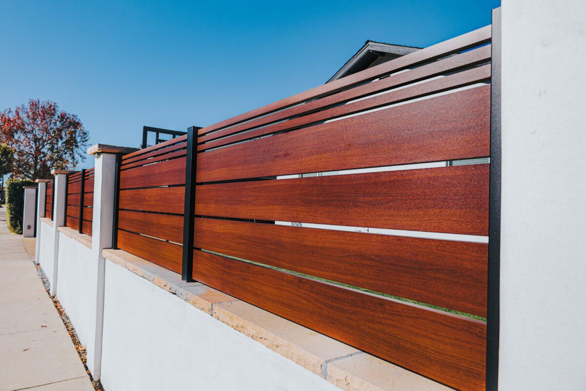 A modern aluminum fence designed to mimic wood texture, enhancing property aesthetics.