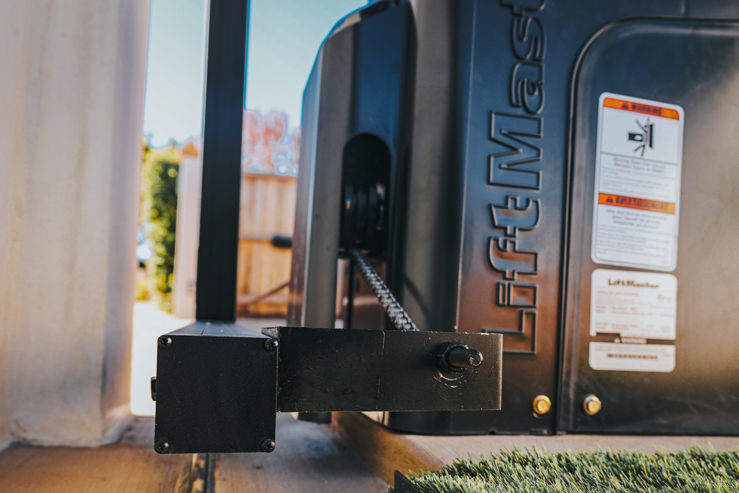 Close-up of an automated gate motor at a fence installation site.