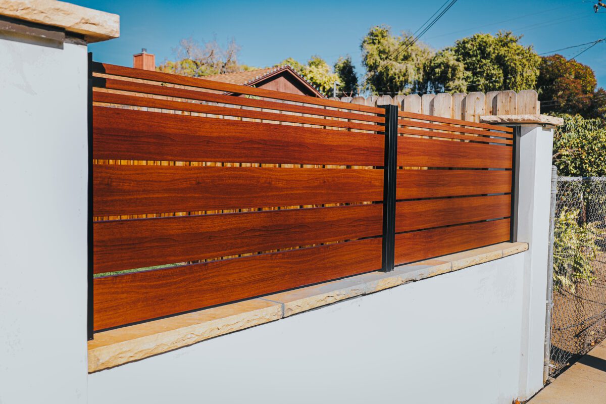 Aluminum fence with a wood-like finish installed in a residential area.
