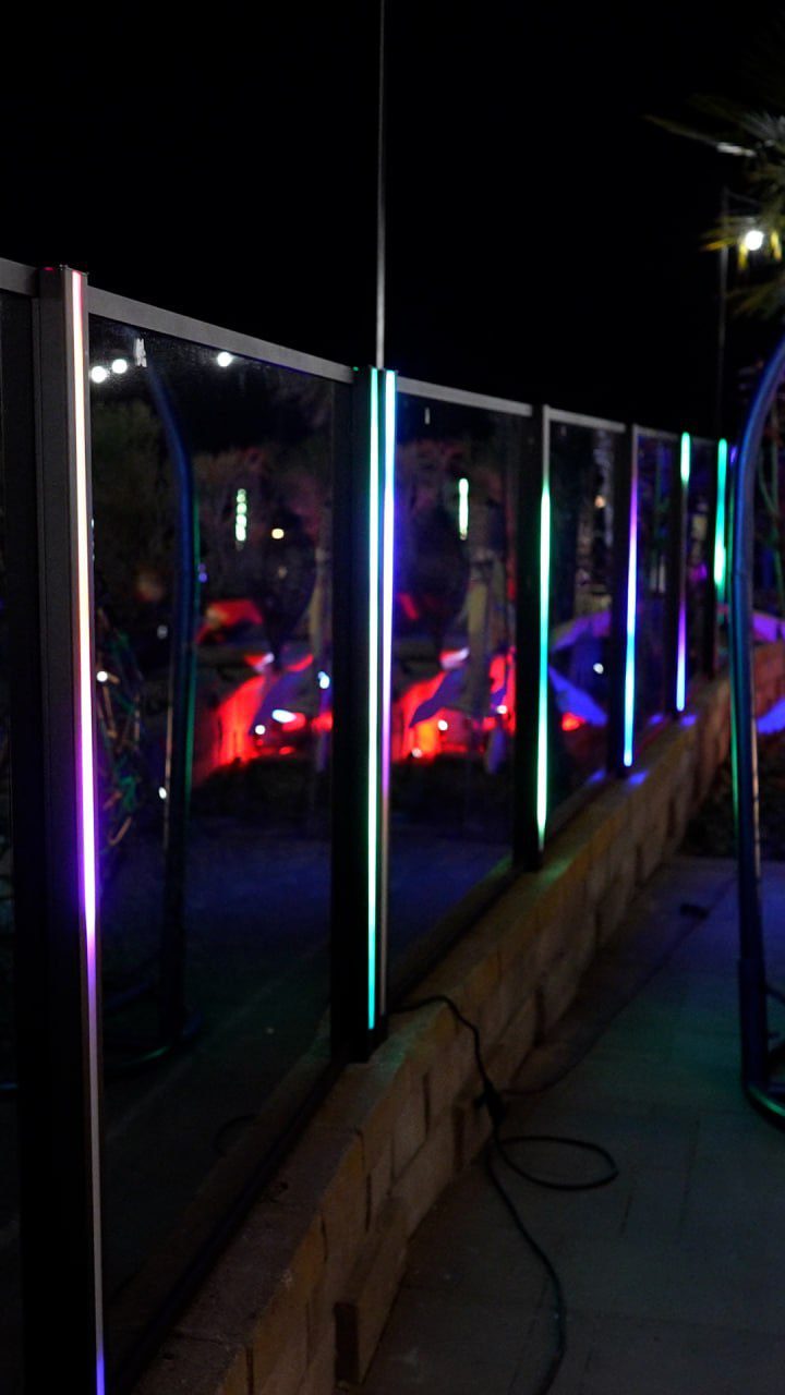 Custom aluminum fence with vibrant LED lights enhances outdoor space at night.