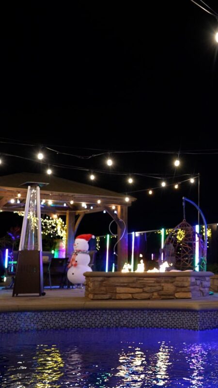 A beautifully lit backyard featuring a festive snowman and vibrant LED lights.