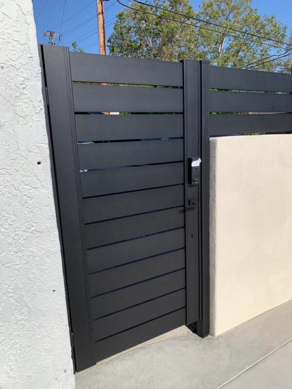 Modern black aluminum fence with a sleek design, showcasing a stylish gate entrance.