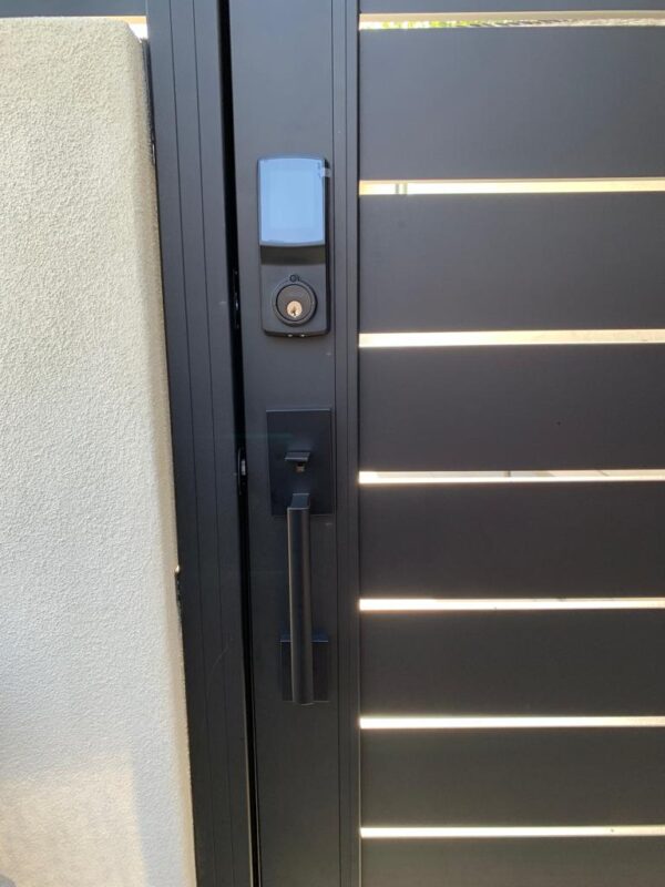 Close-up of a modern black aluminum gate with a secure locking mechanism.