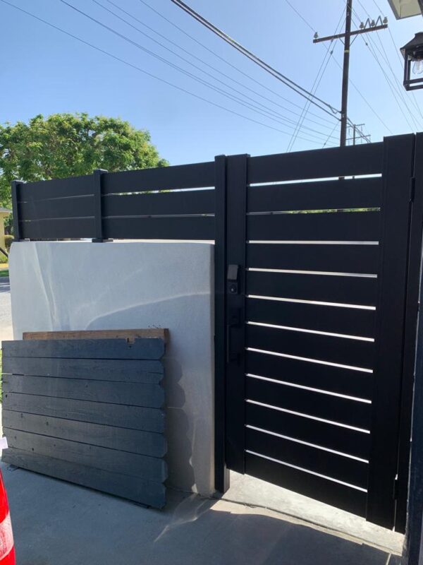 A modern black aluminum fence with a sleek design and gate installed.