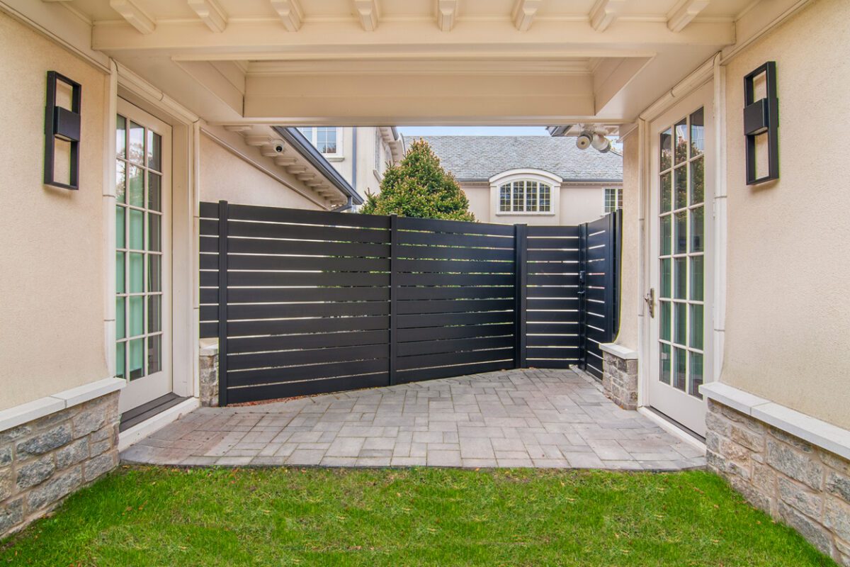 Modern black aluminum fence installation in a residential setting.