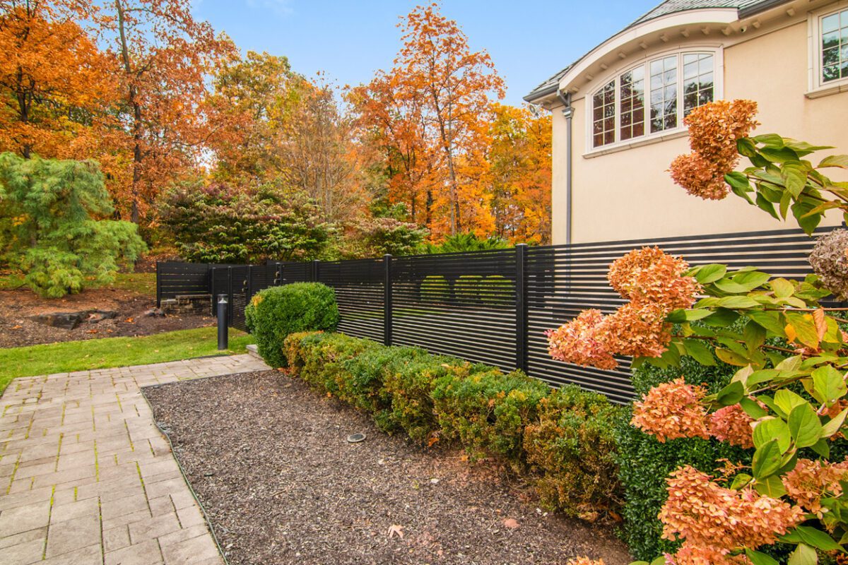 Modern black aluminum fence enhances a beautiful landscaped yard in Cedar Grove, NJ.