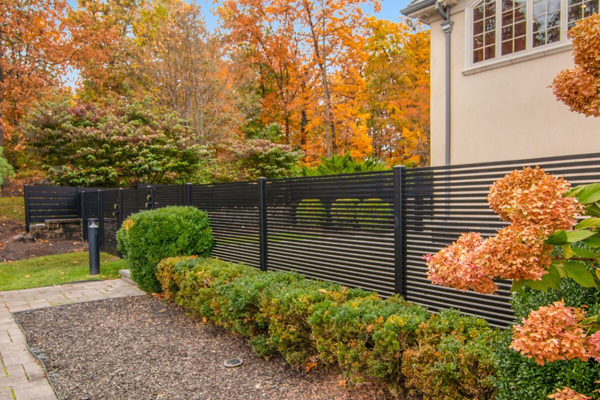 Modern black aluminum fence enhances a vibrant garden in Cedar Grove, NJ.