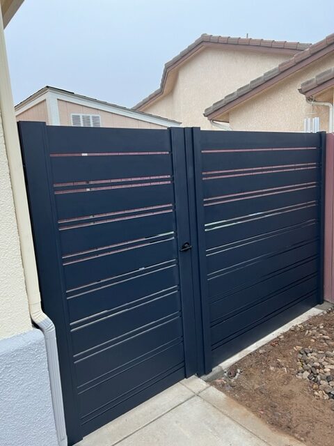 Modern black pedestrian gate installation with sleek design in a residential area.
