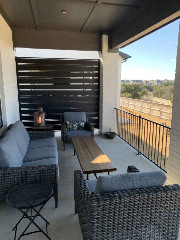 Modern patio featuring a sleek black aluminum privacy screen and stylish furniture.