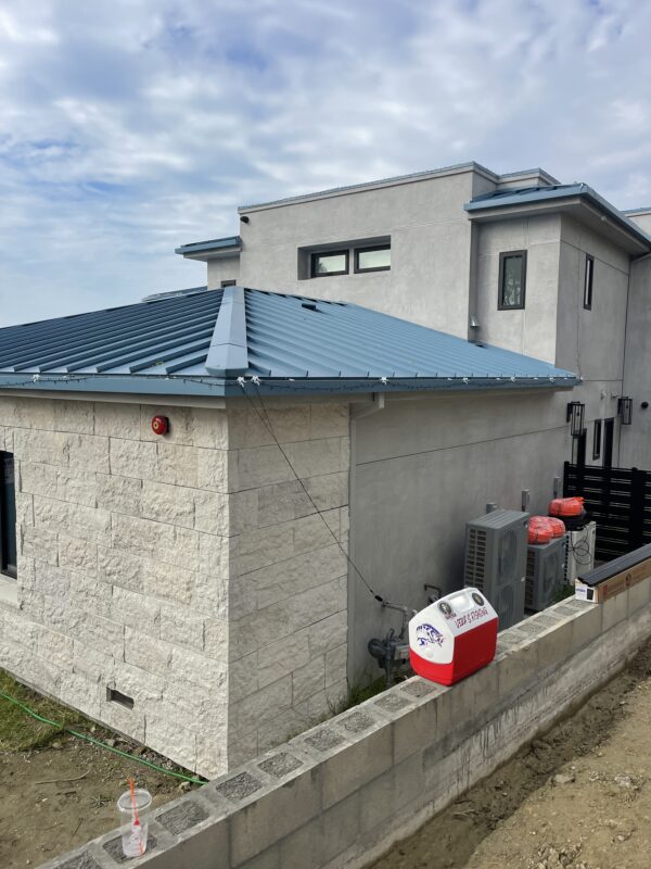 Installation of a black aluminum fence near a modern building in Laguna Beach.