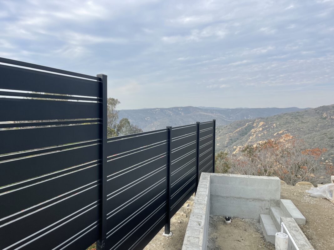 Modern black aluminum fence overlooking a scenic hillside in Laguna Beach.