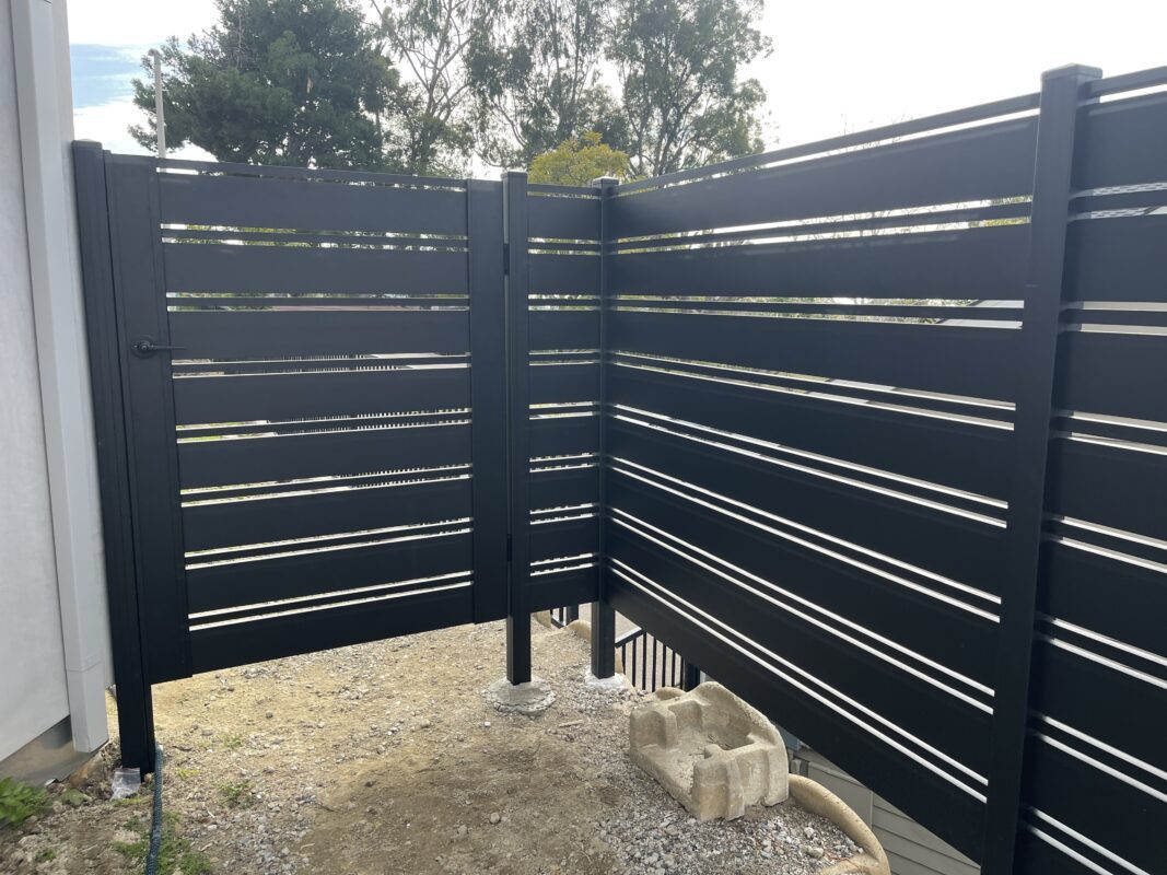 Modern black aluminum fence installation with a stylish design in Laguna Beach.