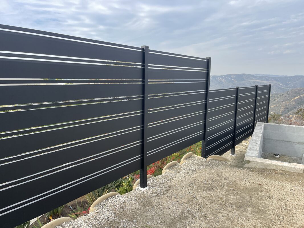 Modern black aluminum fence installed, showcasing sleek lines and beautiful landscaping.
