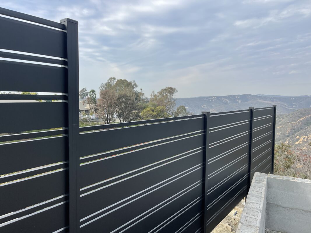 Modern black aluminum fence with scenic view in Laguna Beach, enhancing property security.