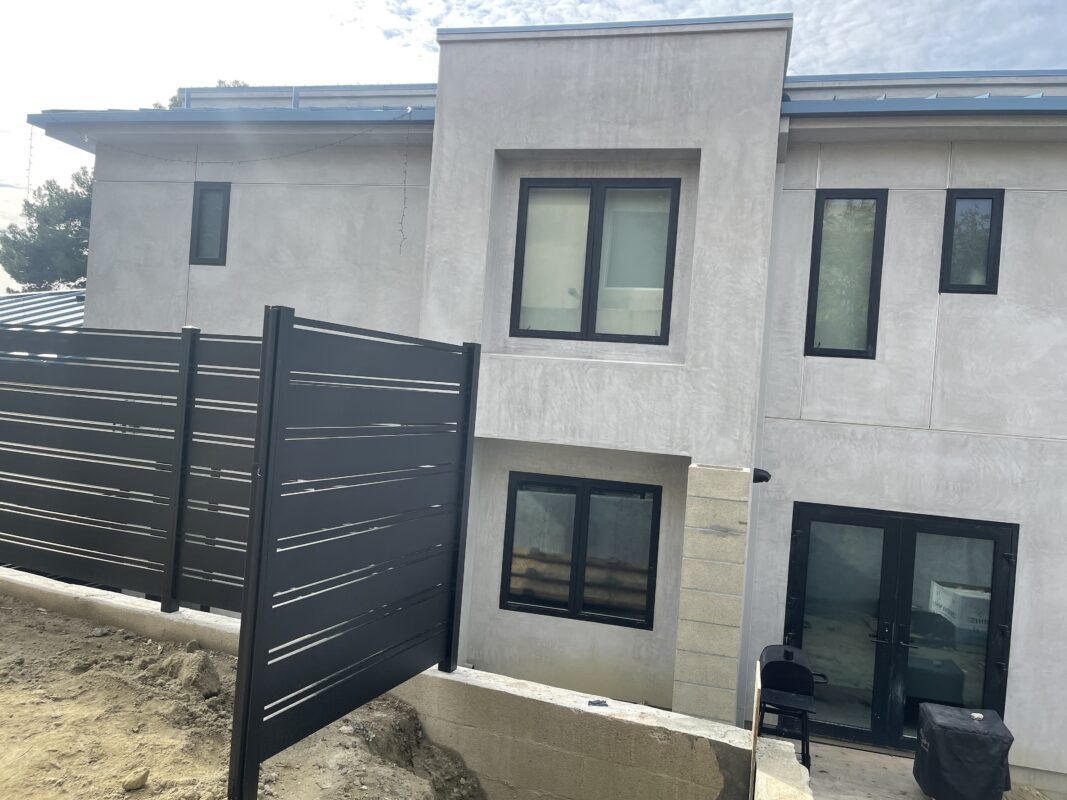 Modern black aluminum fence installed in front of a contemporary building in Laguna Beach.