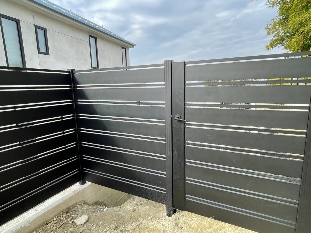 Modern black aluminum fence installation at a residential property in Laguna Beach.