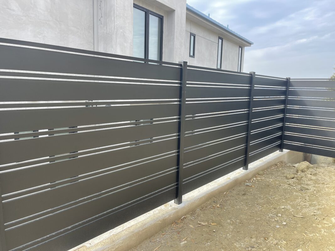 Modern black aluminum fence installed for enhanced security in Laguna Beach.