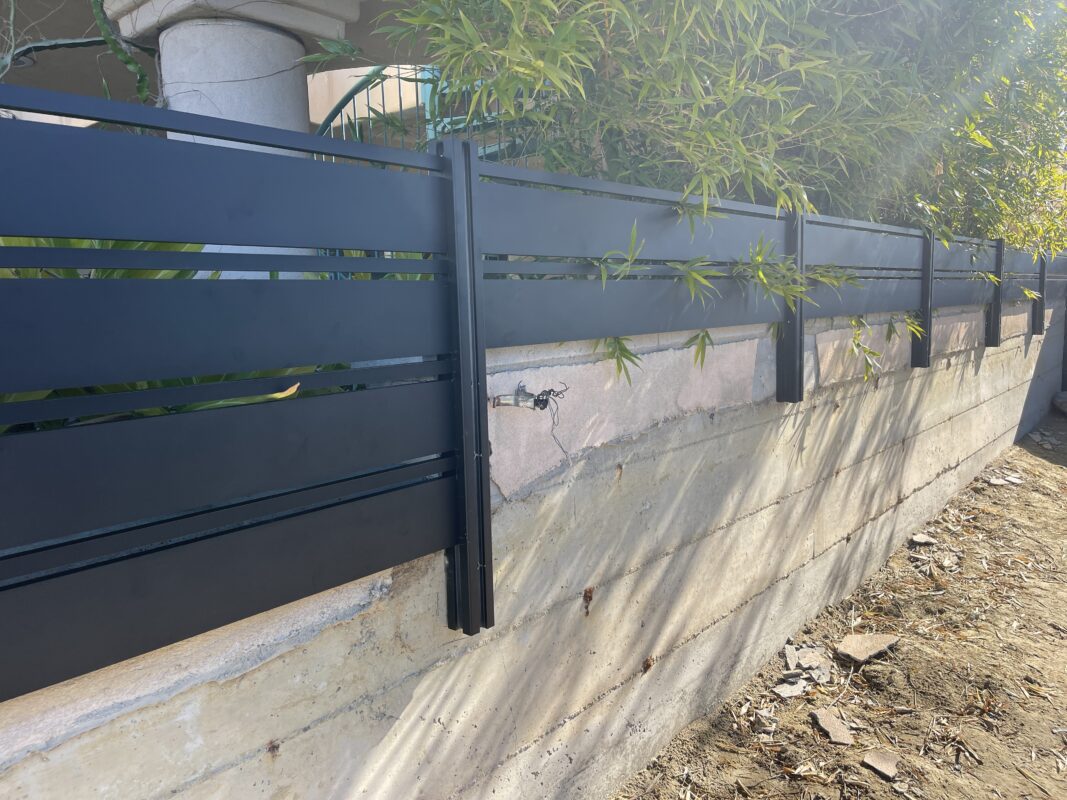 Modern black aluminum fence installed, enhancing security and aesthetics in Laguna Beach.