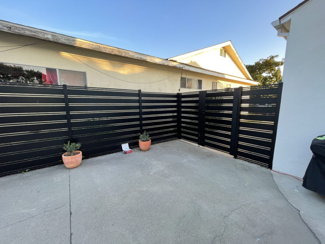 Modern black aluminum fence and gates enhancing a property's outdoor space.