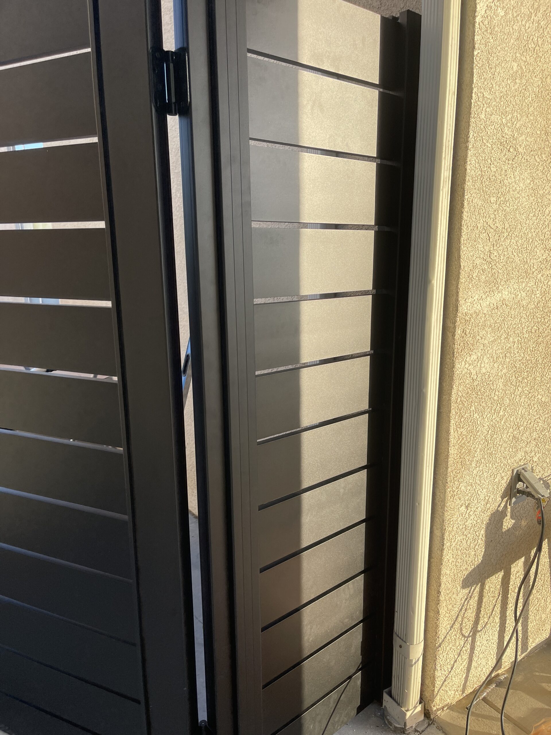 Black aluminum side yard gate installed, showcasing modern design and functionality.