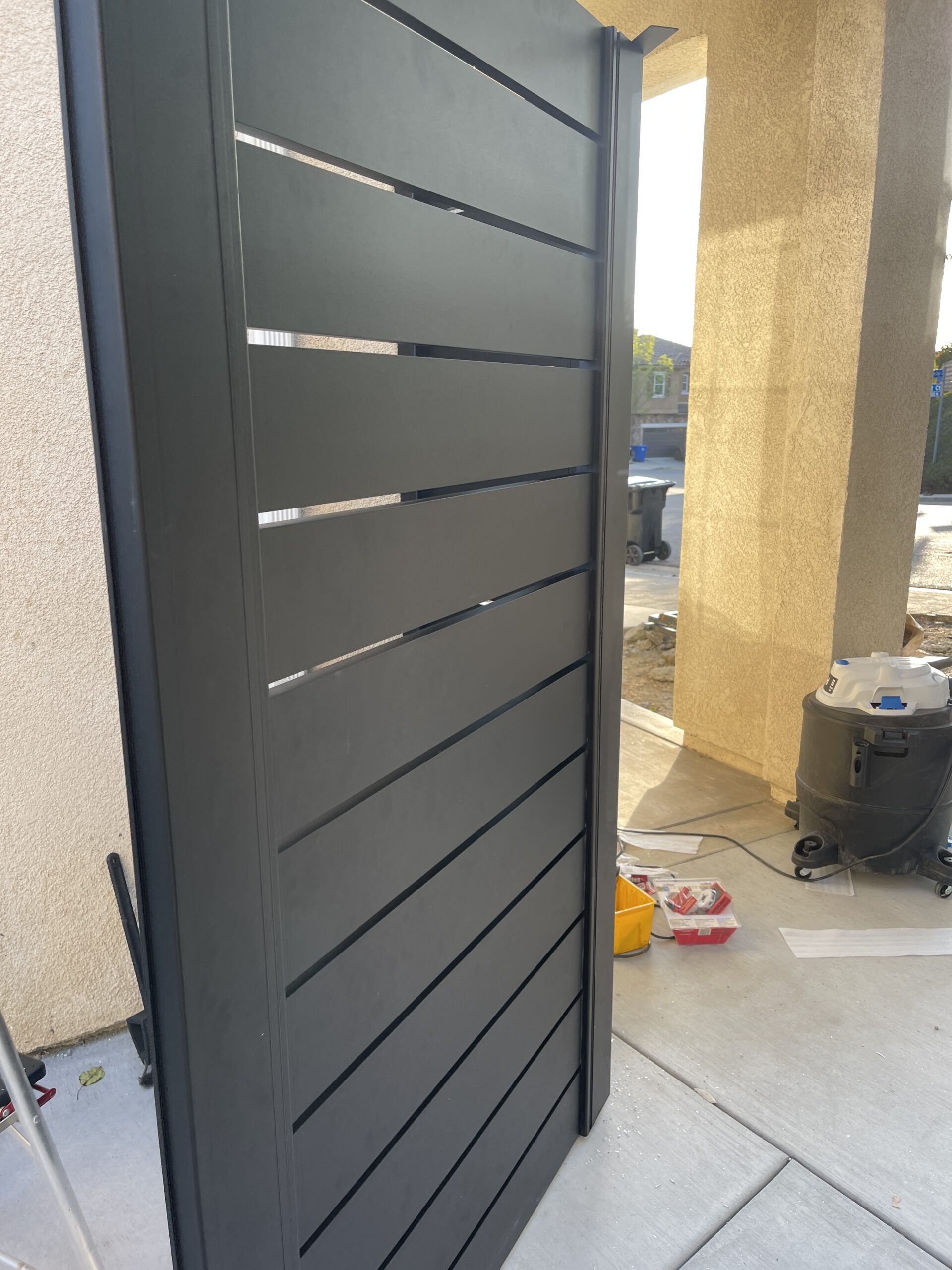 Black aluminum side yard gate with modern design during installation at Sun Valley, CA.