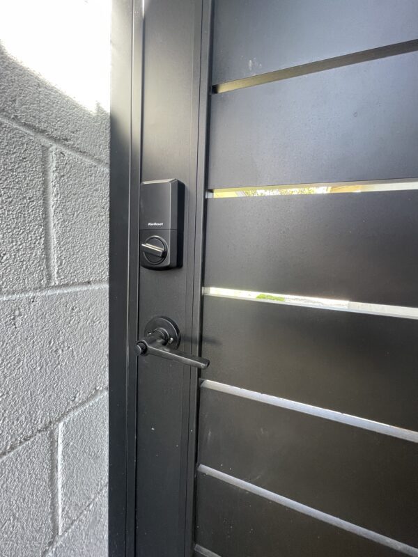 Close-up of a modern black aluminum gate with a sleek locking mechanism.