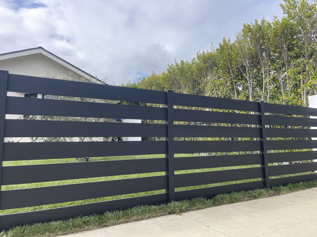 Modern black aluminum fence enhances landscape aesthetics and security.