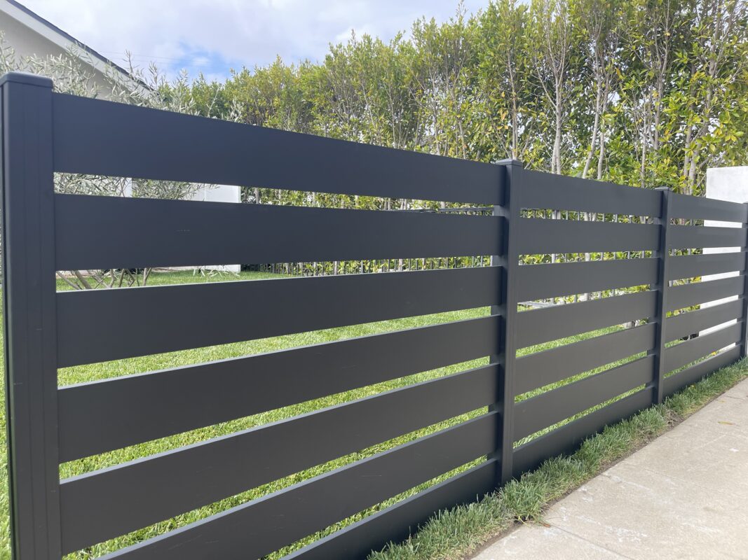 Modern black aluminum fence enhances security and aesthetics in North Hollywood yard.