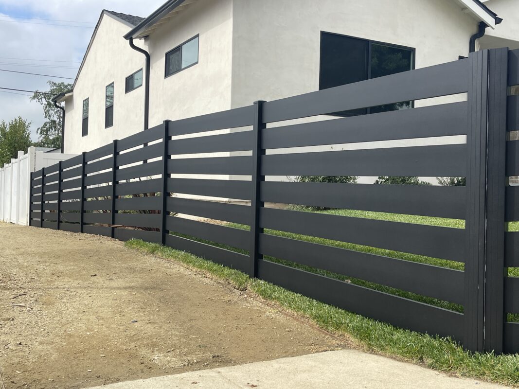 Modern black aluminum fence installation enhancing property security and aesthetics.