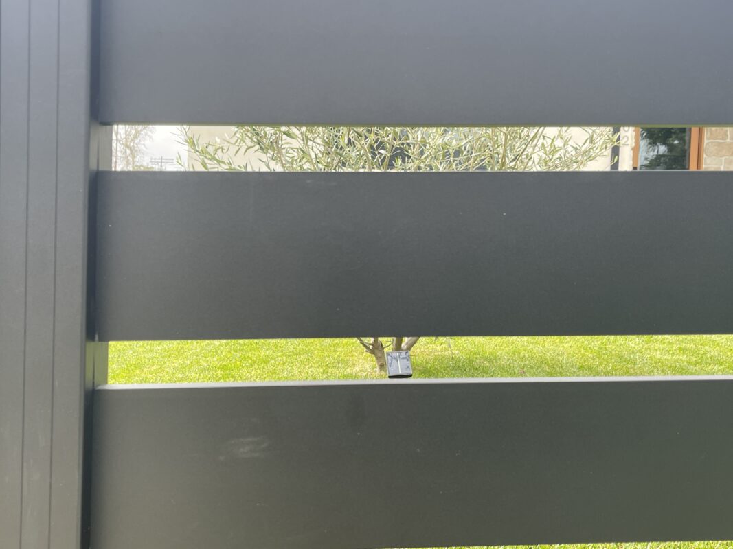 Close-up of a modern black aluminum fence, enhancing property aesthetics and security.