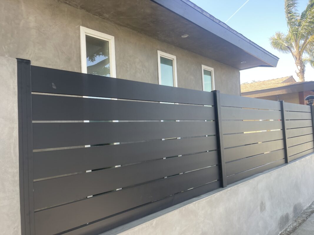 Modern aluminum fence enhances privacy and security in a residential setting.