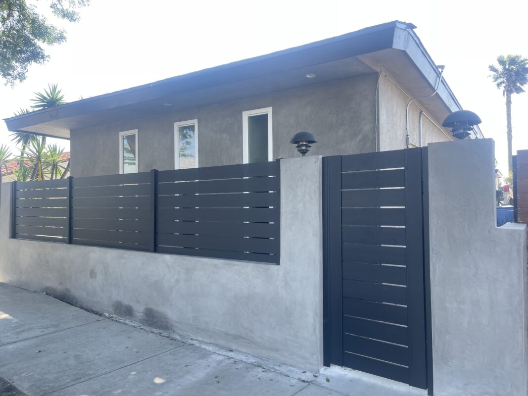 Modern black aluminum fence surrounds a property, enhancing privacy and security.